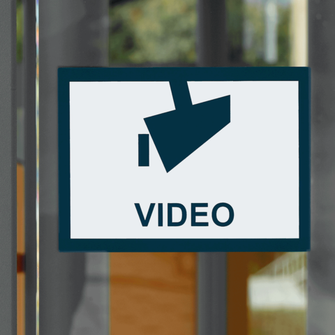 Schild mit einem Kamerasymbol und dem Wort "VIDEO" in Großbuchstaben.